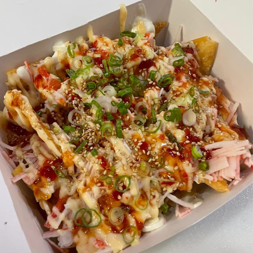 Sushi Box TB's sushi fries, topped with sauces, green onions, sesame seeds, and crab meat.