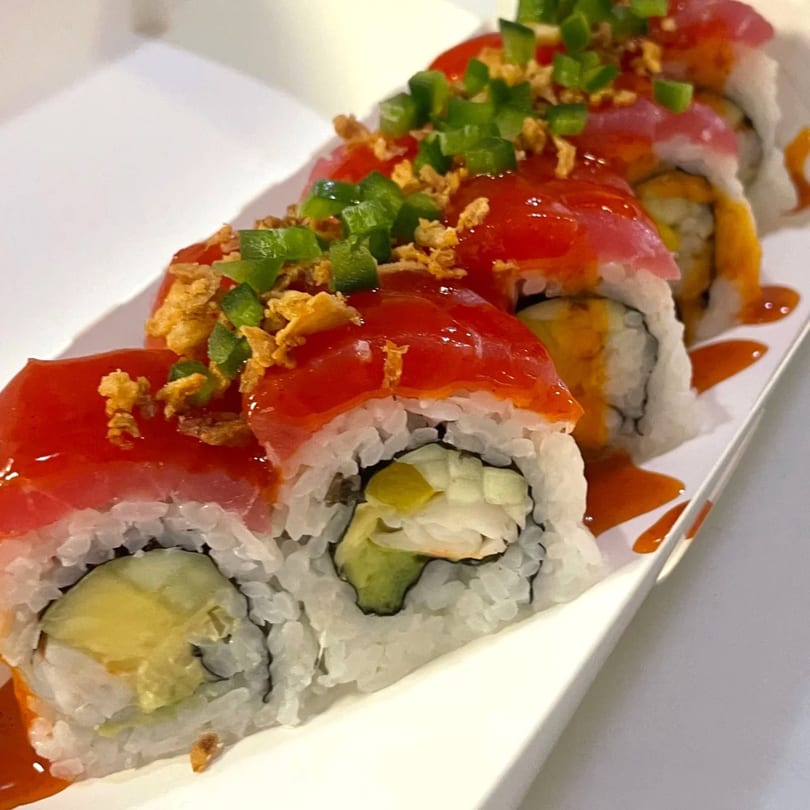 Sushi Box TB sushi roll with red topping, green peppers, and crispy fried onions.